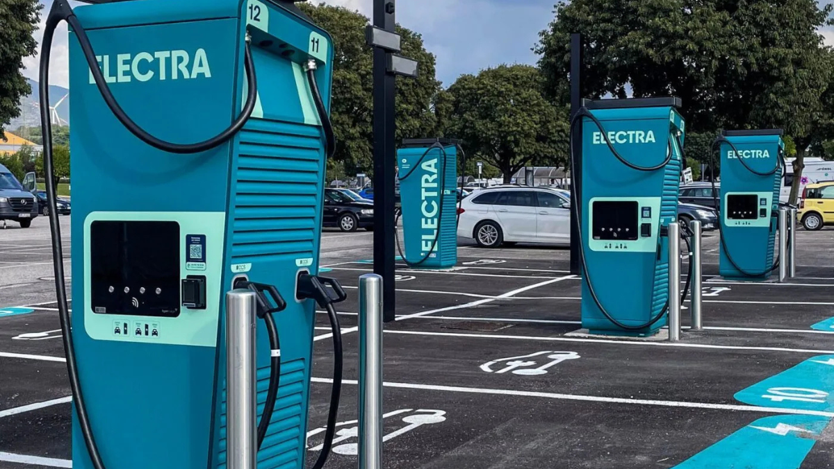 Fast-charging stations in a parking lot with Electra-branded chargers and EVs nearby