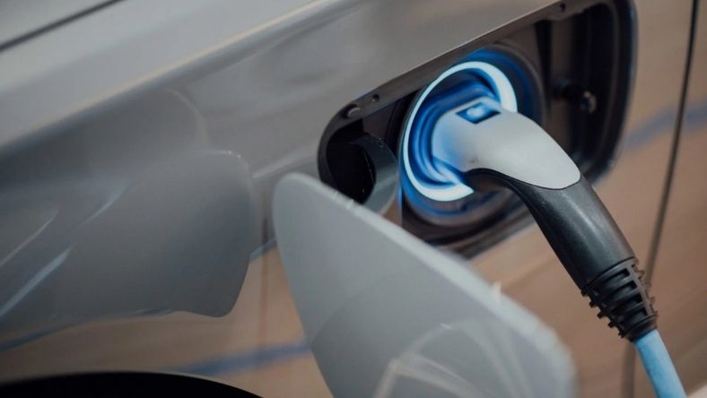 Electric vehicle charging cable plugged into public EV charger port