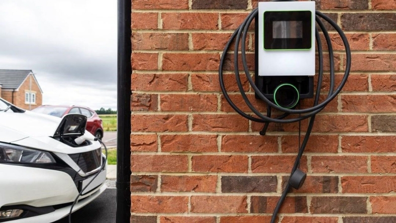 An electric vehicle plugged into a home charging point